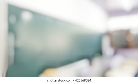 School Classroom In Blur Background Without Young Student; Blurry View Of Elementary Class Room No Kid Or Teacher With Chairs And Tables In Campus.