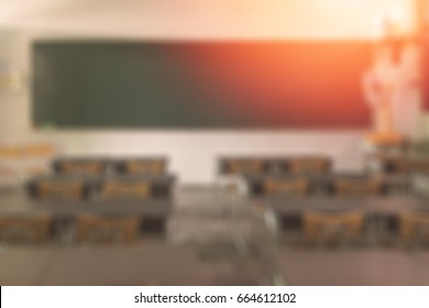 School Classroom In Blur Background Without Young Student; Blurry View Of Elementary Class Room No Kid Or Teacher With Chairs And Tables In Campus.