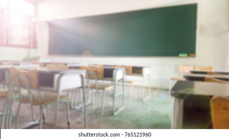School Classroom In Blur Background Without Young Student; Blurry View Of Elementary Class Room No Kid Or Teacher With Chairs And Tables In Campus.