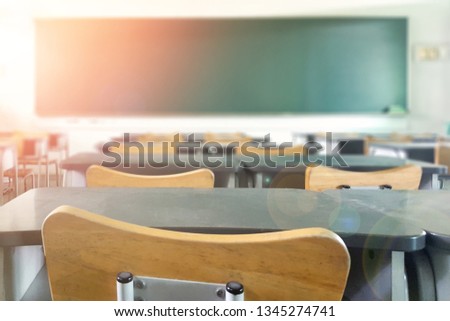 School classroom in blur background without young student; Blurry view of elementary class room no kid or teacher with chairs and tables in campus.