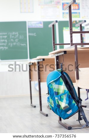 School classroom with school desks and blackboard