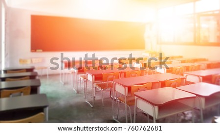 School classroom in selective focus background without young student; Blurry view of elementary class room no kid or teacher with chairs and tables in campus.