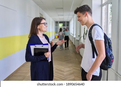 School, college, female teacher talking to a male teenage student in school corridor. Adolescence and education - Powered by Shutterstock