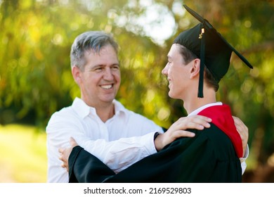 School Or College Graduation Ceremony. Young Man In Gown And Cap, With His Family. Moher And Father Cheer At Celebration Of Successful Diploma Certificate. High School Graduate In Robe And Mortarboard