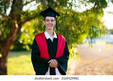 School Or College Graduation Ceremony. Young Man In Academic Regalia, Gown And Cap, Celebration Successful Diploma Certificate. High School Graduate In Robe, Stole And Mortar Board.