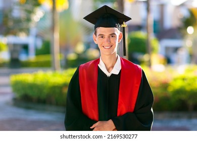 School Or College Graduation Ceremony. Young Man In Academic Regalia, Gown And Cap, Celebration Successful Diploma Certificate. High School Graduate In Robe, Stole And Mortar Board.