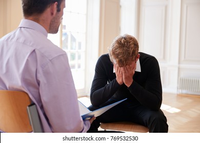 School Counselor Talking To Depressed Male Pupil