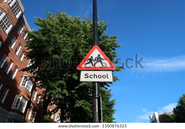 A school\
crossing sign on the side of the\
road.