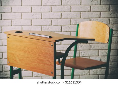 School Desk And Chair On White Brick Wall Background