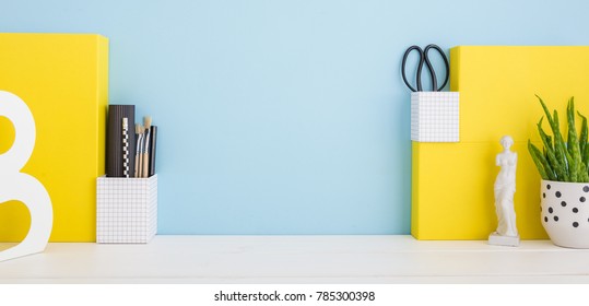 School Desk With A Stationery, Plant And Pencils On A Blue Background