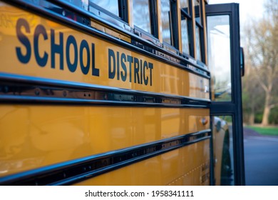 School District Written On The Side Of A School Bus. Door Is Open. No People, Nature Background.