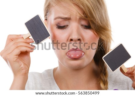 School, education, learning concept. Teenage girl holding little school blackboards and ticking her tongue out. Studio shot on white background.