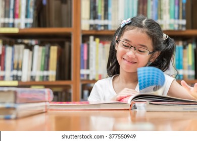 School Education And Literacy Concept With Asian Girl Kid Student Learning And Reading Book In Library Or Classroom