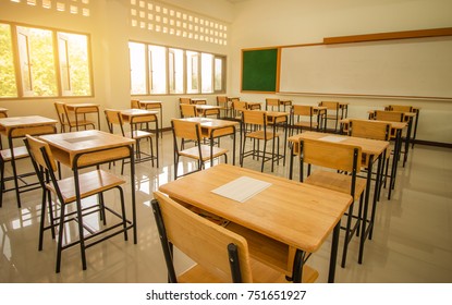 School empty classroom with test sheet or exams paper on desks chair wood and greenboard at high school thailand, education test concept