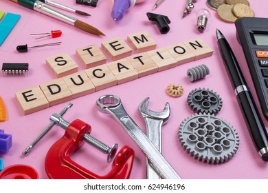 School Equipment With Word STEM Education Over Pink Background In Education STEM Concept. School Desk With Stationery Tools For STEM Learning.