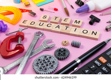 School Equipment With Word STEM Education Over Pink Background In Education STEM Concept. School Desk With Stationery Tools For STEM Learning.