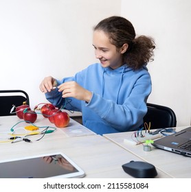 School Experiment With Apples. School Student Extract Electricity From Apples, Use Of The Energy Of A Chemical Reaction. Learning At Table STEM And STEAM Engineering Science Education Class.