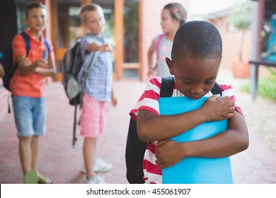 School friends bullying a sad boy in corridor at school - Powered by Shutterstock