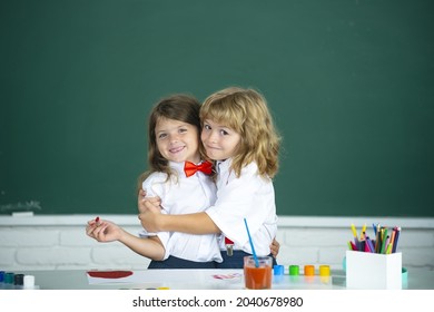 School Friends Hugging. Two School Kids, Girl And Boy Holding Hands Going At School Class In Classroom. Two Primary School Children In A Classroom Hugging Each Other.