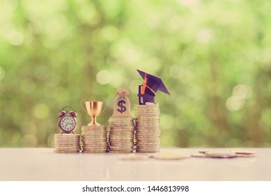 School Funding, Saving For Higher Education Concept : Black Graduation Cap, Campus Diploma, US Dollar Bag, Trophy Cup Of Success Or Winner Reward, A Clock On Rising Coins, Depicts Passage Of Success