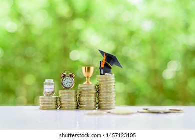 School Funding, Saving For Higher Education Concept : Black Graduation Cap, Campus Diploma, Trophy Cup Of Success Or Winner Reward, Clock, A Saving Jar On Rising Coins, Depicts Passage Way Of Success