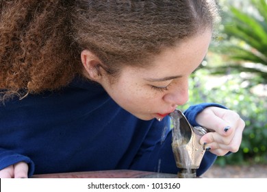 A School Girl Drinking From A Water Fountain.  Horizontal View.