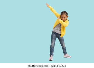 School girl, Happy Asian student school kid hand dancing super hero, Full body portrait isolated on pastel plain light blue background - Shutterstock ID 2311142293