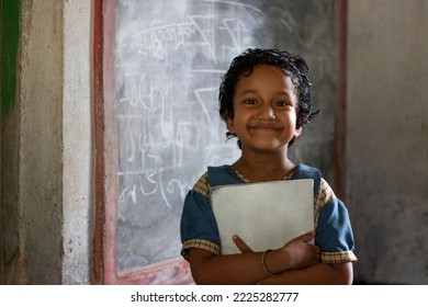 School girl holding book standing at school - Shutterstock ID 2225282777