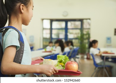 School girl holding food tray in school cafeteria - Shutterstock ID 152942660