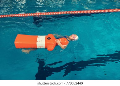 School Girl In A Pool. Water Rescue Training With Dummy