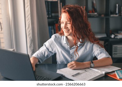 School girl studying with books Laptop preparing for test Exam writing essay doing homework at home, Teenage Student Learning assignment making Notes, Teen Education concept - Powered by Shutterstock