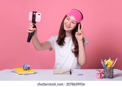 School girl takes a selfie on the phone during a break between online lessons, says hello during video call, distance education concept young blogger shoots tik tok youtube content on the phone