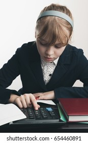 School Girl Using Calculator, Closeup Portrait Over White Wall Background