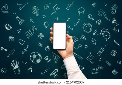 School icons set drawing on chalkboard and hand holding smartphone with blank screen for websites or mobile applications. Back to school concept. Hand drawn background with school supplies - Powered by Shutterstock