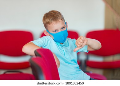 School Kid With Blue Mask Against Virus Shows On Fingers A Sign At Lesson And Event. Safe Back To School During Pandemic Concept. Social Distancing To Fight COVID-19

