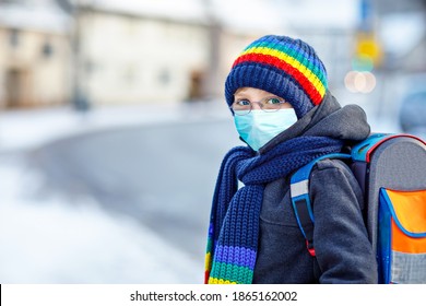 School Kid Boy With Glasses Wearing Medical Mask On The Way To School. Child Backpack Satchel. Schoolkid On Winter Day With Warm Clothes. Lockdown And Quarantine Time During Corona Pandemic Disease