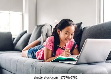 School Kid Little Girl Learning And Looking At Laptop Computer Making Homework Studying Knowledge With Online Education E-learning System.children Video Conference With Teacher Tutor At Home