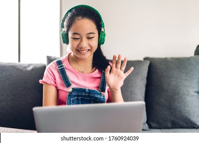 School Kid Little Girl Learning And Looking At Laptop Computer Making Homework Studying Knowledge With Online Education E-learning System.children Video Conference With Teacher Tutor At Home