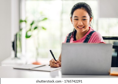 School Kid Little Girl Learning And Looking At Laptop Computer Making Homework Studying Knowledge With Online Education E-learning System.children Video Conference With Teacher Tutor At Home