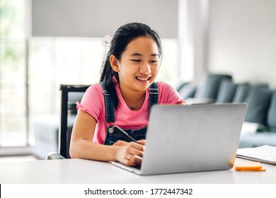 School Kid Little Girl Learning And Looking At Laptop Computer Making Homework Studying Knowledge With Online Education E-learning System.children Video Conference With Teacher Tutor At Home