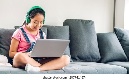 School kid little student girl learning and looking at laptop computer making homework studying knowledge with online education e-learning system.children video conference with teacher tutor at home - Powered by Shutterstock