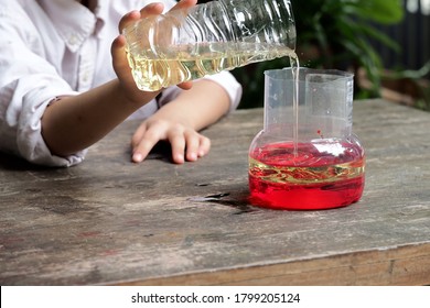 School Kid Making Oil And Water Separator Experiment At Home.Easy D.I.Y. Science Experiment.Experimenting With Oil,water And Dishwashing Detergent Is A Fun Way To Explore Basic Chemistry With Kids.