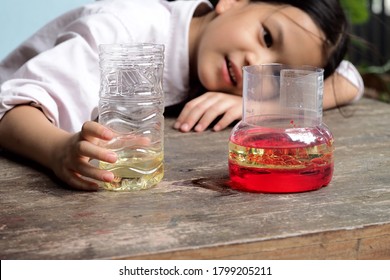 School Kid Making Oil And Water Separator Experiment At Home.Easy D.I.Y. Science Experiment.Experimenting With Oil,water And Dishwashing Detergent Is A Fun Way To Explore Basic Chemistry With Kids.