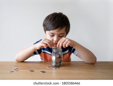 School Kid Putting Money Coins Into Clear Jar, Child Counting His Saving Money, Young Boy Holding Coin On His Hands, Children Learning About Saving For Future Concept