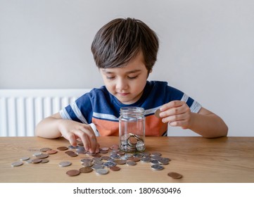 School Kid Putting Money Coins Into Clear Jar, Child Counting His Saving Money, Young Boy Holding Coin On His Hands, Children Learning About Saving For Future Concept