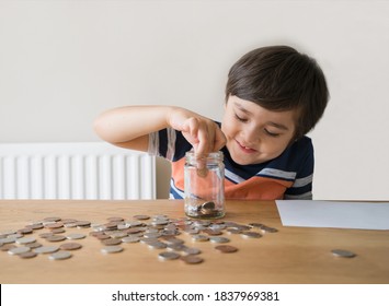 School Kid Putting Money Coins Into Clear Jar, Child Counting His Saving Money, Young Boy Holding Coin On His Hands, Children Learning About Saving For Future Concept