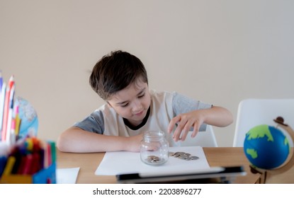 School Kid Putting Money Coins Into Clear Jar, Child Counting His Saving Money, Young Boy Holding Coin On His Hands, Children Learning About Saving For Future Concept