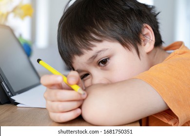 School Kid In Self Isolation Using Tablet For Homework,Child Sad Face Lying Head Down Looking Out Deep In Thought, Boy Stay At Home During Covid-19 Lock Down,
Social Distance Learning Online Education