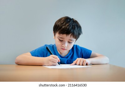 School Kid Using Black Pen Drawing Or Writing The Letter On Paper, Young Boy Doing Homework, Child With Pen Writing Notes In Paper Sheet During The Lesson.Cute Pupil Doing Test, Homeschooling Concept