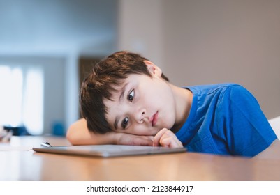 School kid using tablet for homework, Child bored face lying head down looking out deep in thought, Boy learning online class room at home, E-learning or Homeschooling education concept - Shutterstock ID 2123844917